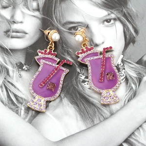 Fashionable cocktail cup earrings with purple enamel, crystals and pearls on magazine