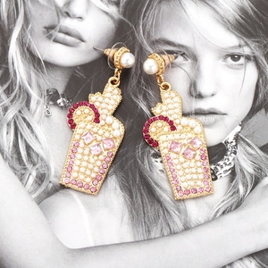 Chic cocktail glass drop earrings with pearls and rhinestones on a stylish portrait backdrop