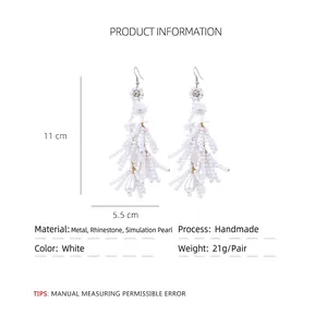 Bohemian white flower tassel earrings with faux pearls and rhinestones on white background