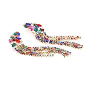 Gros plan de boucles d'oreilles à pampilles avec strass multicolores sur base dorée