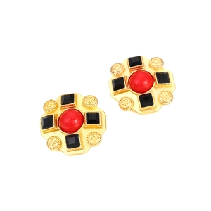 Macro detail of vintage baroque earrings with red and black gems and golden relief patterns