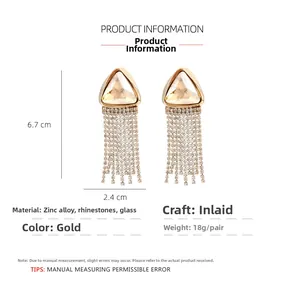 Detail view of gold rhinestone tassel earrings with triangle crystal and 6.7cm dimensions