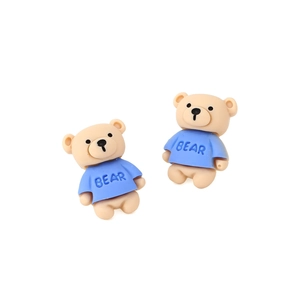 Gros plan de boucles d'oreilles ours 3D en résine avec t-shirts bleus imprimés