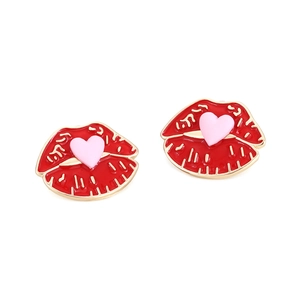 Gros plan sur les boucles d'oreilles lèvres en émail rouge avec cœur rose et bord doré