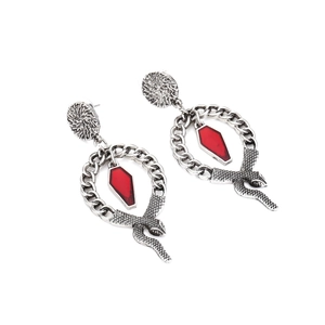 Détail de boucles d'oreilles serpent gothiques avec pendentif cercueil rouge et anneaux