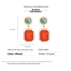 Detail view of square geometric resin earrings with crystals and gold zinc alloy frames