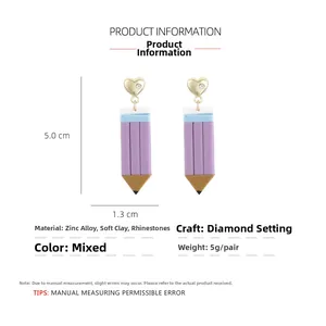 Macro detail of handmade clay pencil earrings with gold heart studs and purple finish