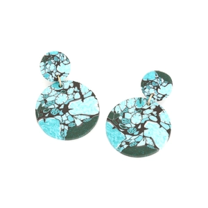 Gros plan de boucles d'oreilles rondes avec motif turquoise et texture de mosaïque