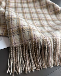 Gros plan détaillé sur le tissu à carreaux doux et les franges artisanales beige et brun