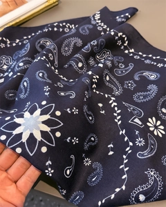 Detail of navy blue paisley silk scarf with herringbone texture and hand-rolled edges