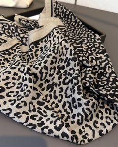 Detailed macro shot of leopard print scarf showing woven linen texture and black border