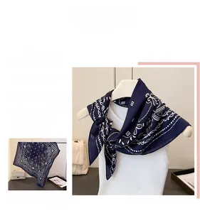 Détail d'un foulard carré bleu marine à motif cachemire avec sac à main blanc élégant