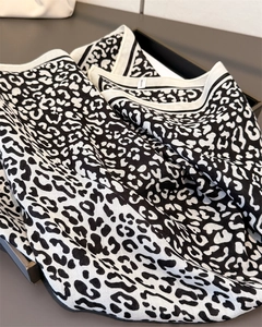 Close-up of black and white leopard print scarf with textured weave and hemmed edges