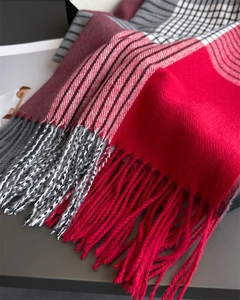 Close-up of red and grey plaid cashmere scarf featuring detailed soft tassels and knit texture
