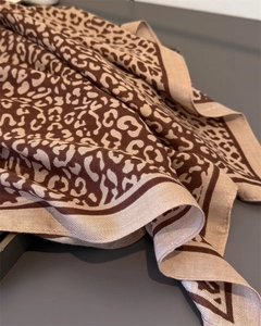 Detailed close-up of leopard print scarf with fine twill edges and premium fabric texture