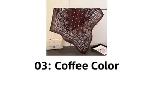 Détail d'un foulard en soie marron café avec motif cachemire et sac à main blanc