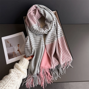 Close-up of soft thick plaid scarf with pink grey tassels and cozy knit texture