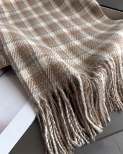 Détail de l'écharpe classique à carreaux marron avec franges et texture douce