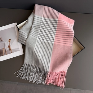 Detail of soft plaid scarf with tassels in pink and grey showing cashmere texture