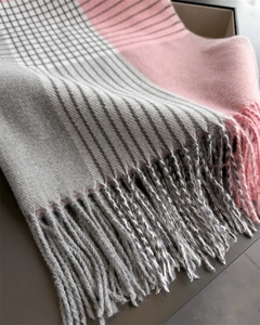 Detailed view of the plaid scarf with soft gray pink fringe and cashmere-like texture