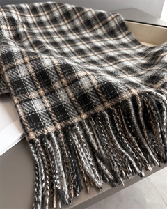 Gros plan d'une écharpe à carreaux épaisse avec texture cachemire et longues franges