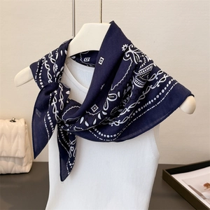 Détail du foulard bleu marine aux motifs géométriques blancs sur un mannequin de couture
