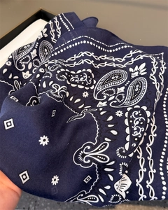 Vue détaillée d'une écharpe en coton bleu marine à motif paisley et texture douce
