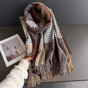 Close-up of thick plaid scarf with long tassels and soft cashmere-like texture