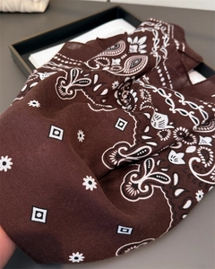 Détail du foulard en soie marron foncé avec motif paisley et texture en sergé doux