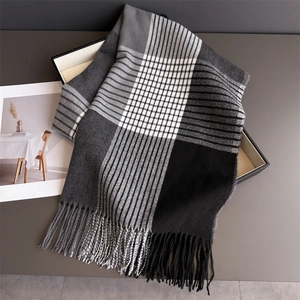 Detailed view of classic black and grey plaid scarf with soft cashmere-like fringe texture