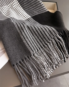 Detail of classic plaid scarf texture with grey tassels and soft knit material