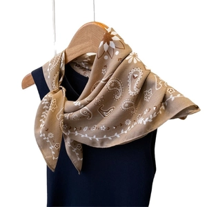 Brown paisley herringbone silk-feel neck scarf displayed on a wooden hanger with black top