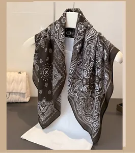 Detailed view of brown paisley pattern cotton-linen scarf on white clothing hanger