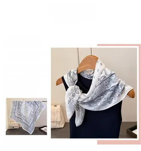 Detail of blue Paisley pattern on white silk-like fabric scarf for women