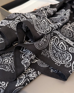 Detail of black paisley print fabric showing fine twill weave and smooth texture