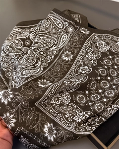 Detailed close-up of dark olive paisley print fabric with intricate floral patterns