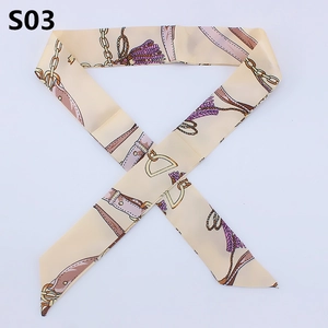 Close-up of narrow twilly scarf with retro chain and purple tassel patterns on beige silk