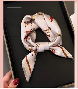 Detailansicht eines Seidenschals mit Vintage-Pferdedruck auf einem schwarzen Display-Tablett