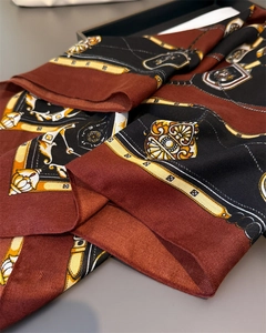 Détail d'un foulard en soie de luxe avec motifs équestres et texture sergé élégante