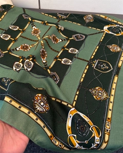 Détail d'un foulard équestre vintage montrant des motifs de harnais et de soie verte