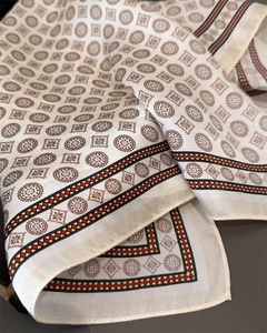 Detaillierte Nahaufnahme des Seidenschals mit Retromuster und elegantem Cremeton