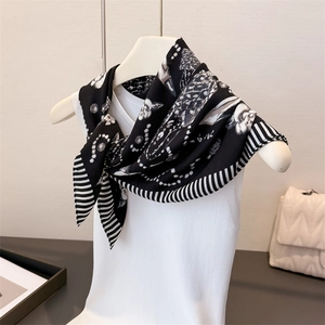 Elegant black and white herringbone silk scarf with abstract patterns on white mannequin