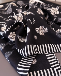 Detail of herringbone linen-feel scarf with camellia and geometric floral patterns