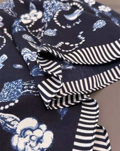 Close-up of navy blue scarf fabric showing herringbone texture and floral pattern