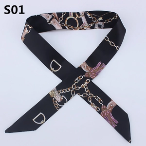 Detail view of black silk twilly with gold chain and pink tassel print for handbag handles