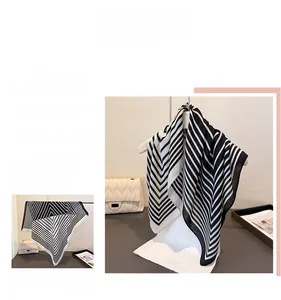 Gros plan du motif géométrique à chevrons sur le tissu du foulard en coton et lin