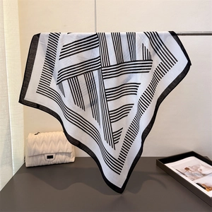 Détail du motif géométrique à rayures noir et blanc sur une écharpe en coton et lin