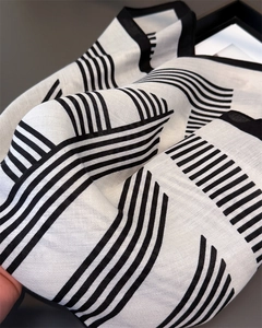 Détail du tissage à chevrons et motifs à rayures géométriques sur une écharpe en coton doux
