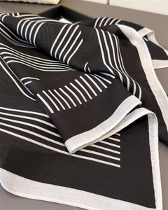 Gros plan d'un foulard en soie à rayures géométriques avec texture sergée fine