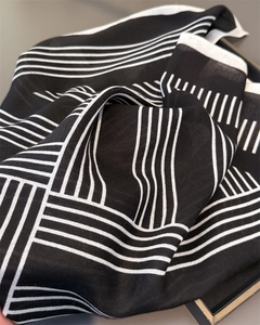 Vue macro du motif géométrique à chevrons sur le tissu du foulard carré noir et blanc